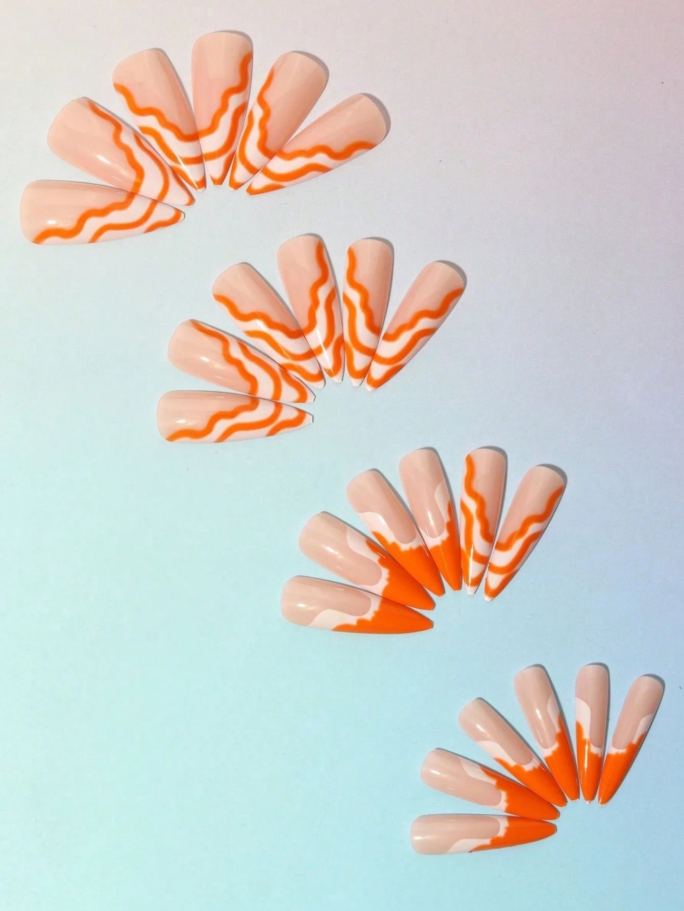 Nail art design with orange and white pattern